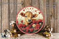 a round wooden plaque with a cow's face surrounded by red roses and greenery, along with the text "Love Grows Here".
