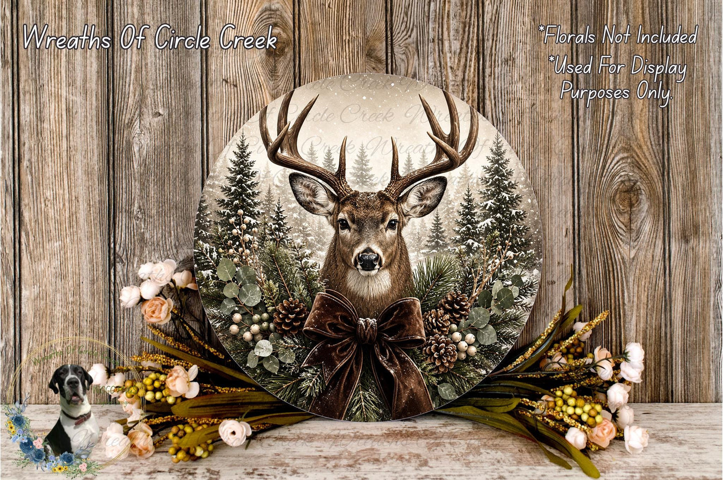 A deer head is displayed in a wreath, surrounded by pine trees, flowers, and a brown ribbon bow.