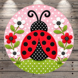 A round, decorative image featuring a red and black spotted ladybug surrounded by white flowers and green leaves, set against a pink background with white polka dots.