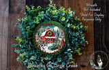 A wreath with a red barn and Christmas trees, surrounded by greenery, with a small image of a truck in the center.