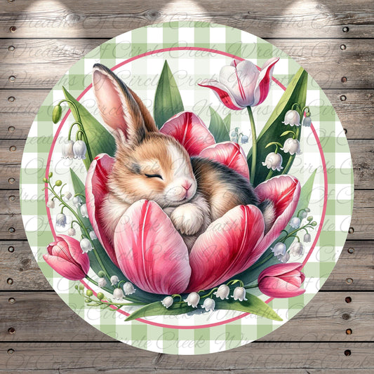 A cute bunny is peacefully sleeping on a large pink tulip surrounded by lily pads and other flowers, all set against a green and white checkered background.