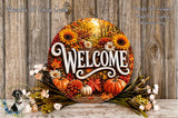 a circular welcome sign surrounded by autumn decorations, including sunflowers, pumpkins, and other seasonal elements. The sign is placed on a wooden surface, and there are flowers and foliage surrounding it.
