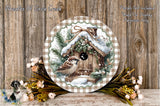 a round wooden plaque with a birdhouse design, surrounded by a wreath of flowers and greenery, placed on a wooden surface.