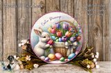 A decorative Easter wreath featuring a white bunny holding a basket of colorful tulips and eggs, surrounded by a floral arrangement and a wooden background.