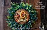 a wreath made of various plants and flowers, including a sunflower and a butterfly, with a wooden sign that says "Welcome" in the center.