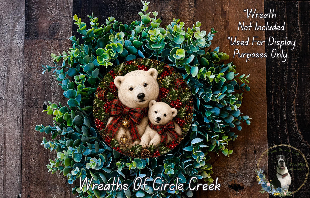 A wreath made of green leaves and red and black plaid ribbons, with two white bears wearing red and black plaid ribbons sitting in the center.