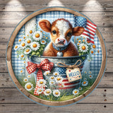 A cow is sitting in a bucket filled with flowers, surrounded by a patriotic American flag and a "Hello" sign.