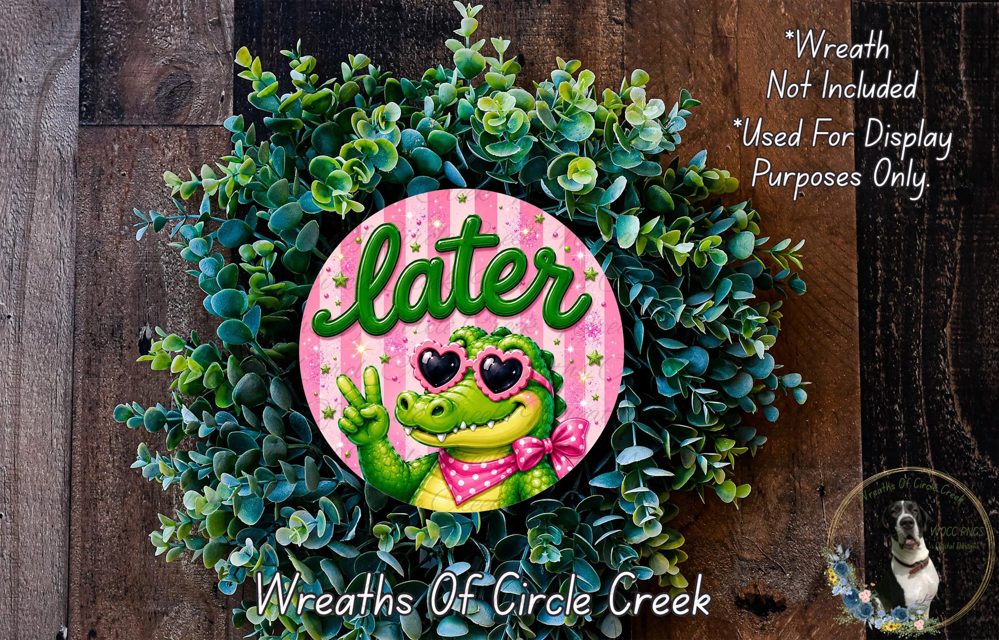 a wreath with a green alligator wearing sunglasses and a pink bow, surrounded by a lush green plant.