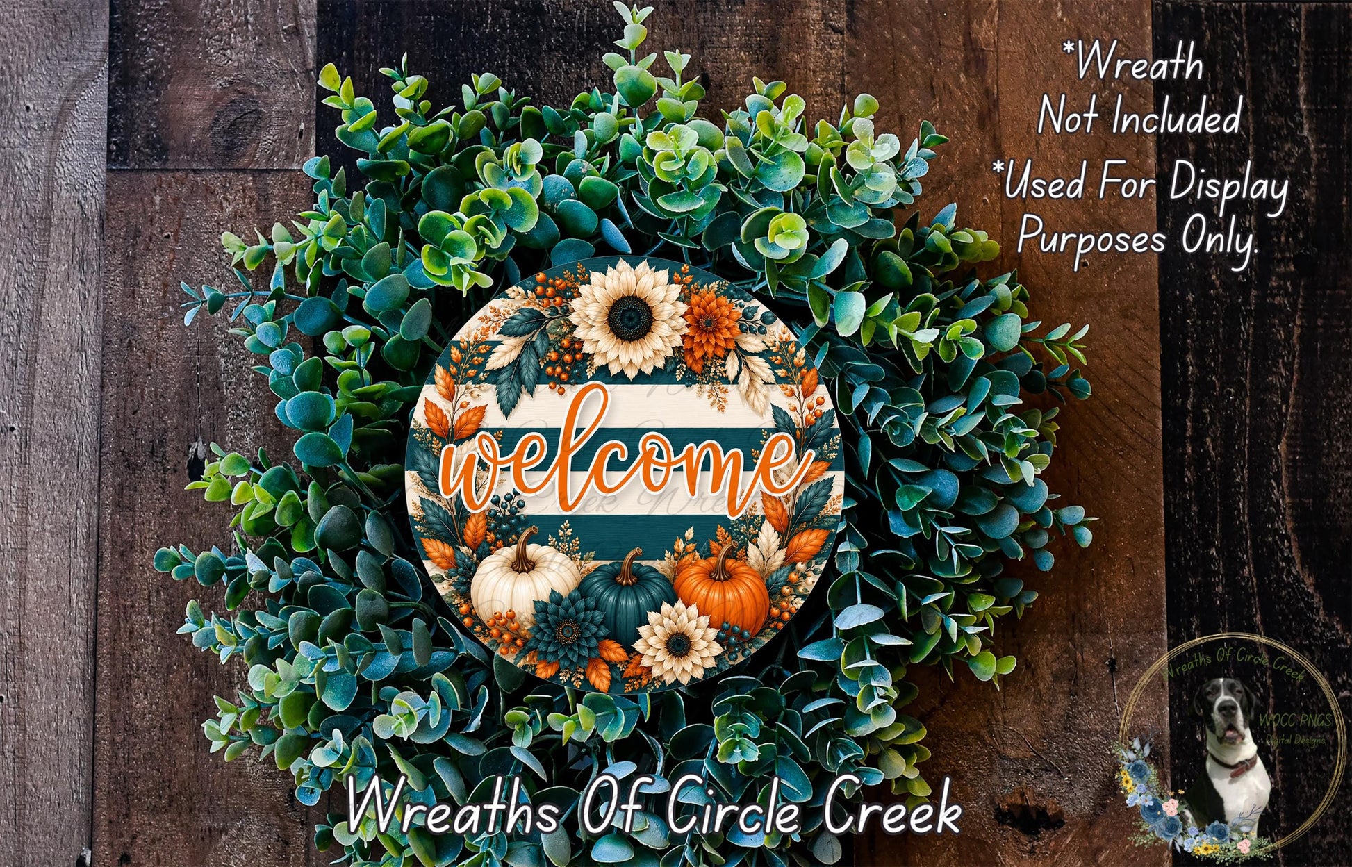 a wreath with a welcome sign in the center, surrounded by various fall foliage and flowers. The wreath is displayed on a wooden surface, and there is a small dog in the bottom right corner of the image.