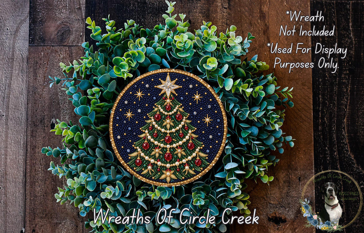 A wreath made of green leaves and a blue circular ornament with a Christmas tree design, placed on a wooden surface.