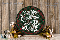A festive Christmas wreath with the text "May Your Christmas Be Furry & Bright" displayed on it, surrounded by a floral arrangement and a dog.