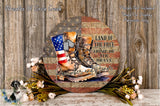 a round wooden sign with an American flag design and a pair of boots, surrounded by flowers and placed on a wooden surface.