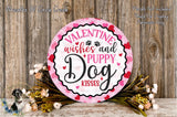 a round sign with a pink and white color scheme, surrounded by flowers and greenery. The sign displays the text "Valentine Wishes and Puppy Kisses" in a decorative font.
