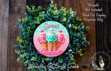 a wreath made of green foliage and decorated with pink and blue ice cream cones, along with the text "Sweet Summer" written on it.