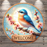 A blue bird perched on a branch with pink flowers, surrounded by a wooden sign that says "WELCOME".