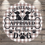 a circular sign with a checkered background and a message about guests and approval by the dog.