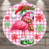 A pink flamingo wearing a Santa hat and scarf, with snowflakes and green elf boots, is the central focus of the image.