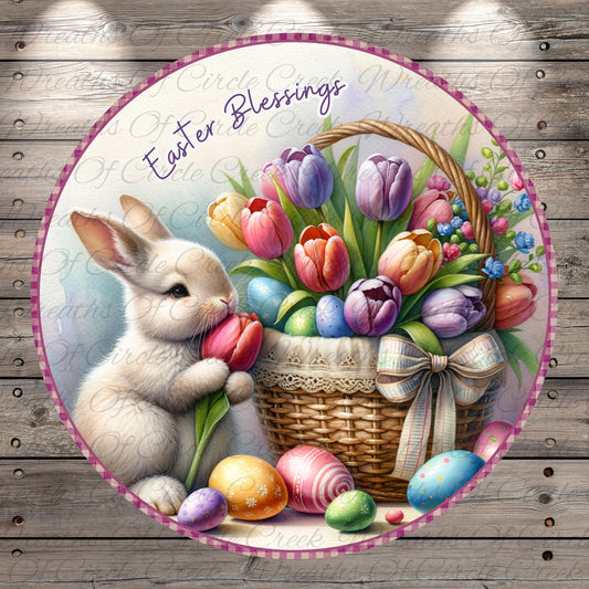 A white rabbit is sitting next to a basket filled with colorful Easter eggs and flowers, with the text "Easter Blessings" written above the scene.