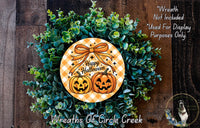A Halloween wreath made of green foliage and two carved pumpkins, with a text that reads "Happy Halloween" and "Wreath Not Included Used For Display Purposes Only".