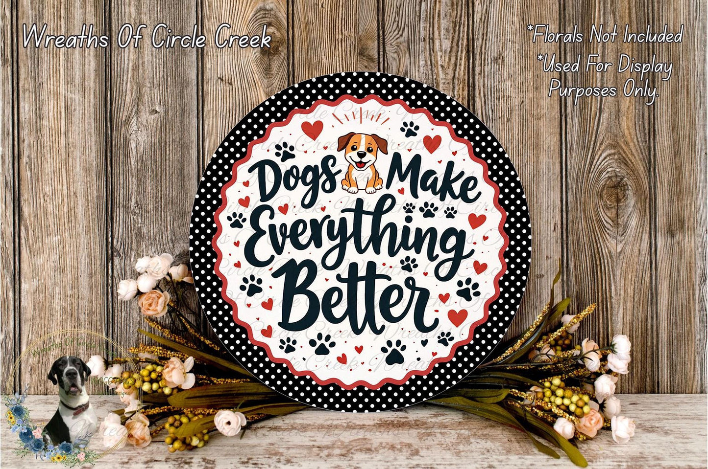A decorative sign with the text "Dogs Make Everything Better" surrounded by paw prints and flowers, placed on a wooden surface.