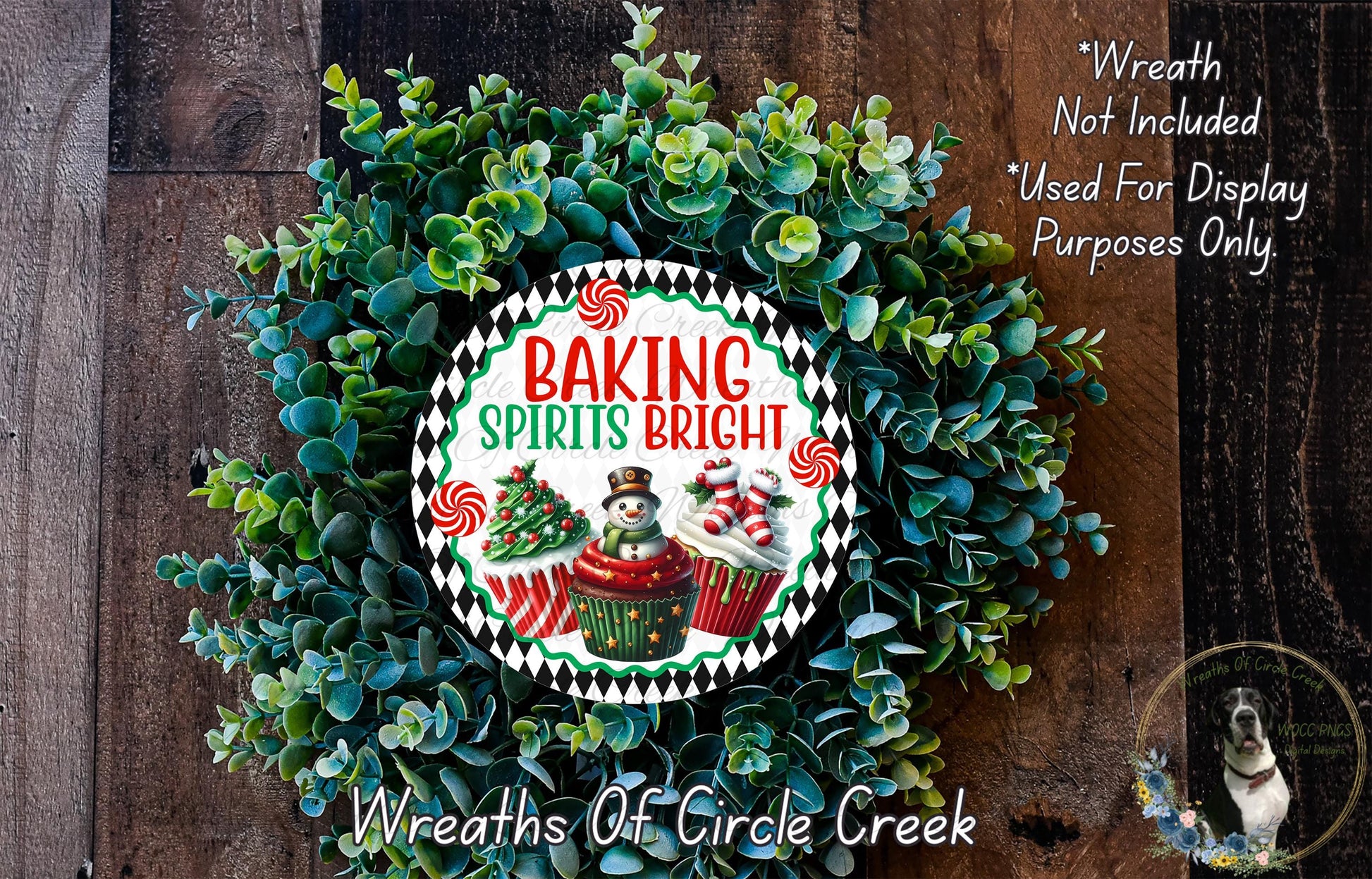 a wreath made of green leaves and decorated with a sign that reads "Baking Spices Bright". The wreath is placed on a wooden surface, and there is a small dog visible in the bottom right corner of the image.