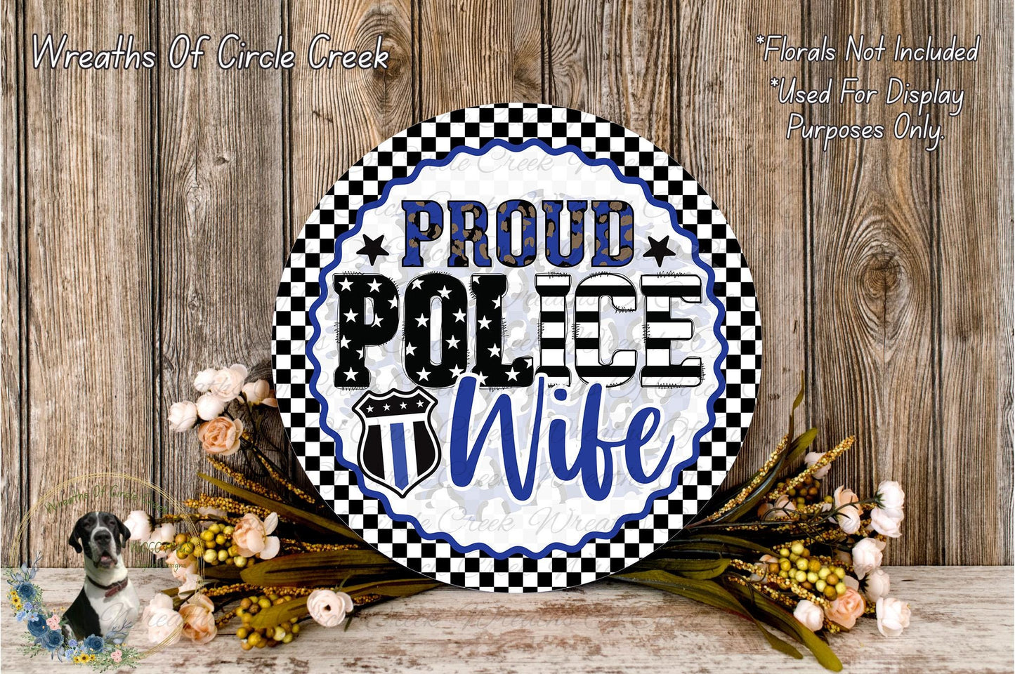 A decorative sign with the text "PROUD POLICE WIFE" displayed prominently, surrounded by a floral arrangement and a wooden background.