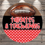 A football is displayed on a wooden surface, with the text "tailgates & touchdowns" written below it.