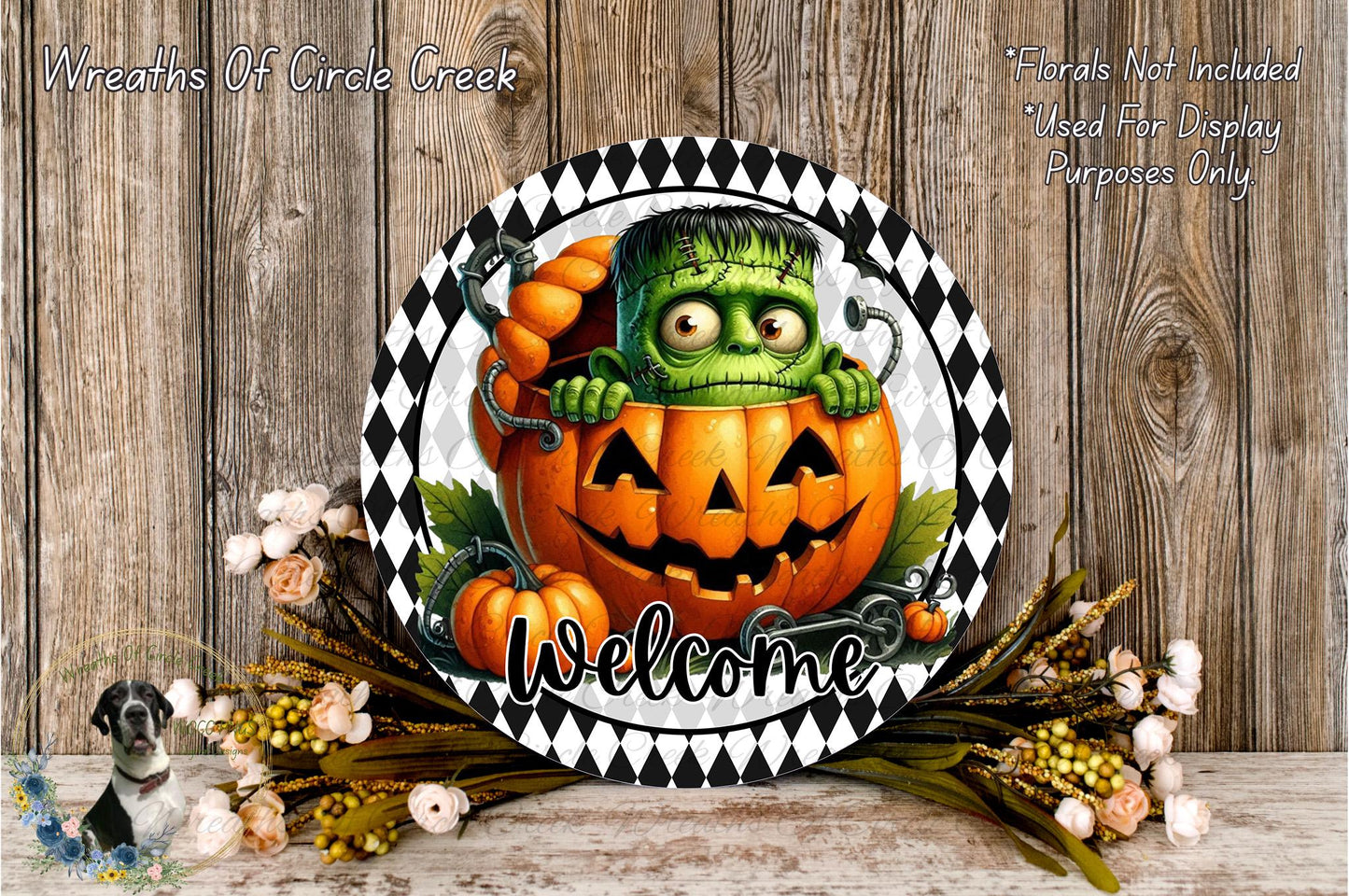a Halloween-themed welcome sign with a green monster, a jack-o-lantern, and a floral arrangement. The sign is displayed on a wooden surface, and the text "Welcome" is written below the jack-o-lantern.