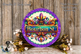 a decorative round sign with the text "Bourbon St." in the center, surrounded by a floral arrangement and a wooden background.