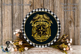 a round sign with a police officer's badge, surrounded by flowers and a wooden background.