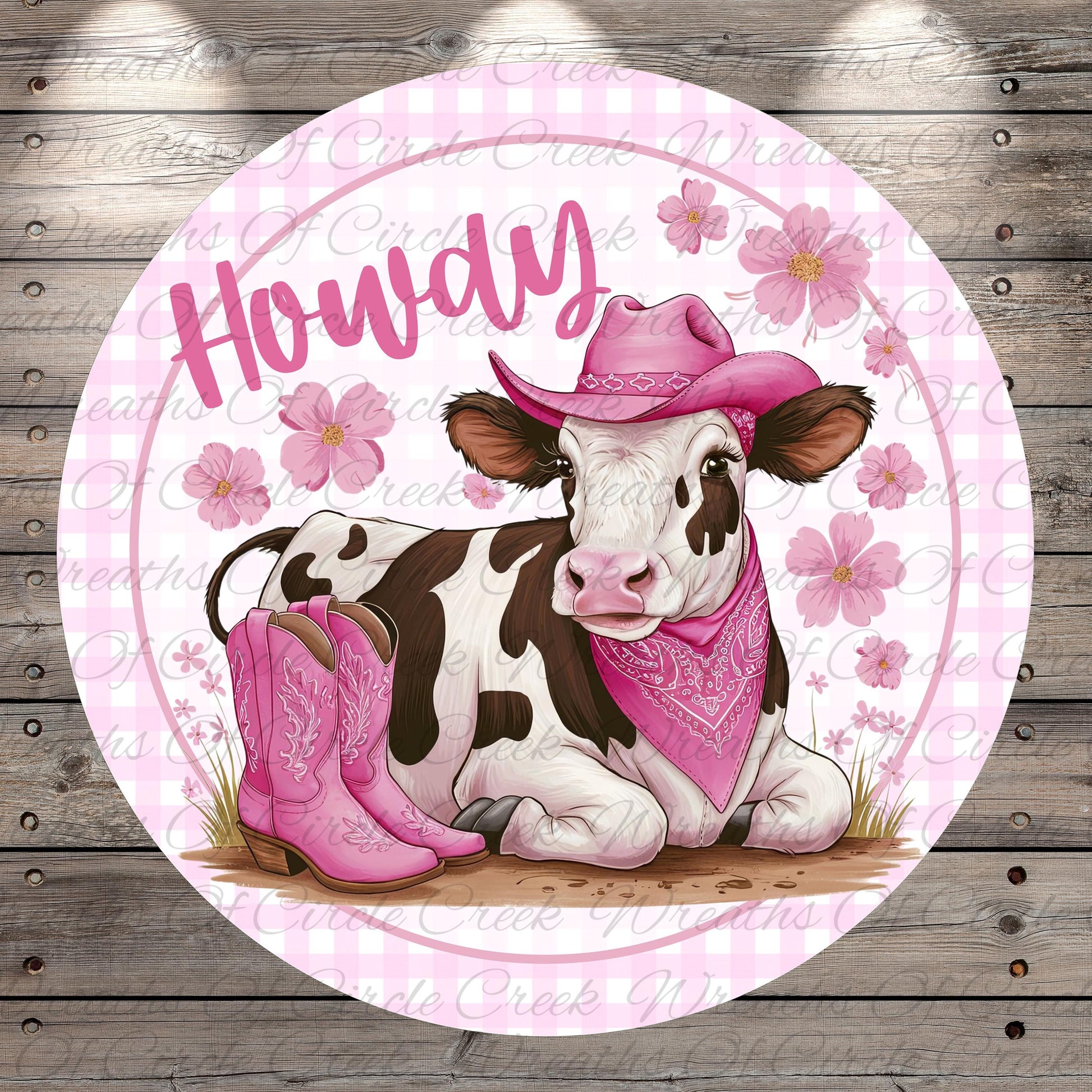A cow wearing a pink cowboy hat and boots, with a pink bandana around its neck, is sitting on a grassy area with pink flowers in the background.