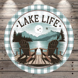 A circular design featuring a lake with a wooden dock and two Adirondack chairs, surrounded by mountains and pine trees. The text "LAKELIFE" is prominently displayed above the chairs.