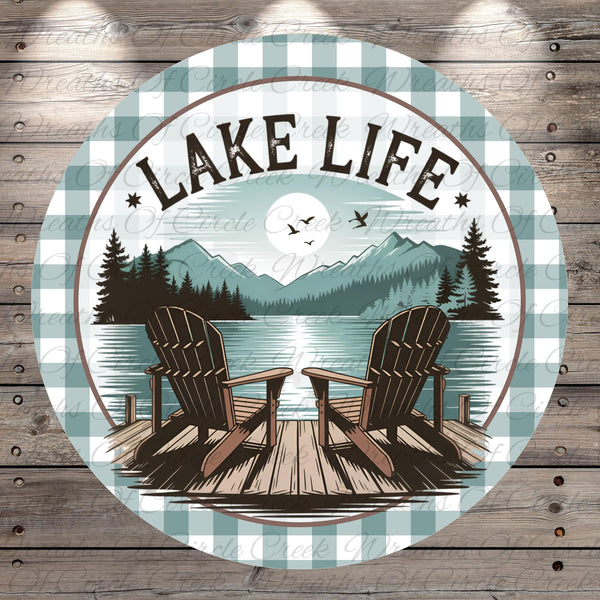 A circular design featuring a lake with a wooden dock and two Adirondack chairs, surrounded by mountains and pine trees. The text "LAKELIFE" is prominently displayed above the chairs.