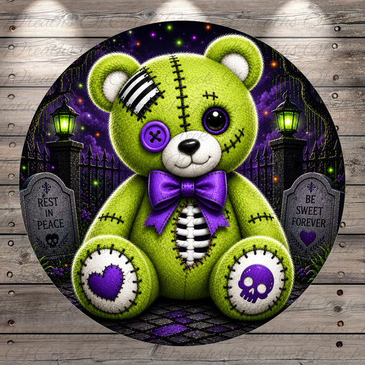 A green teddy bear with purple accents and a skull design sits in a dark, spooky graveyard scene.