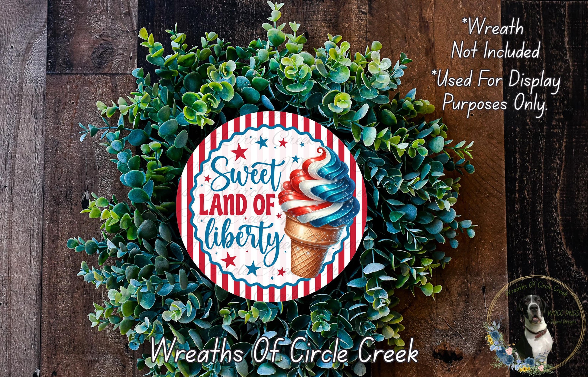 a wreath made of green leaves and a circular sign with the text "Sweet Land of Liberty" on it, placed on a wooden surface.