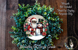 A wreath made of evergreen branches and featuring a Santa Claus and a snowman, with a sign that says "Merry Christmas".