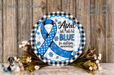 a round sign with a blue ribbon and puzzle pieces, surrounded by flowers and a wooden background. The sign reads "In April WE WEAR BLUE for autism awareness".