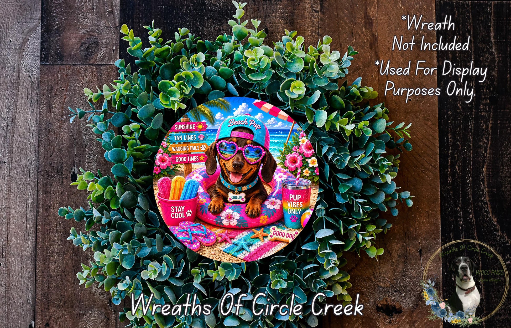 A wreath made of green leaves and flowers, with a dog wearing sunglasses and a hat, sitting on a beach towel.