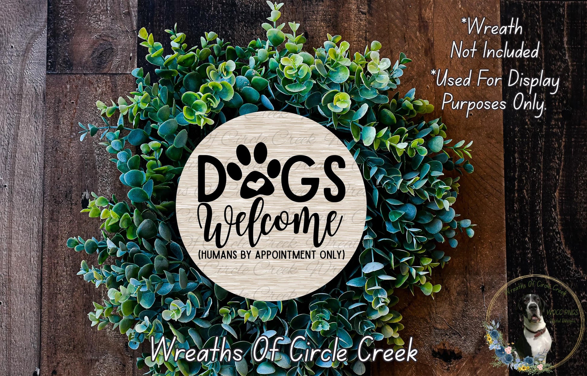 a wreath made of green leaves and a circular sign that says "Dogs Welcome" in bold black letters.