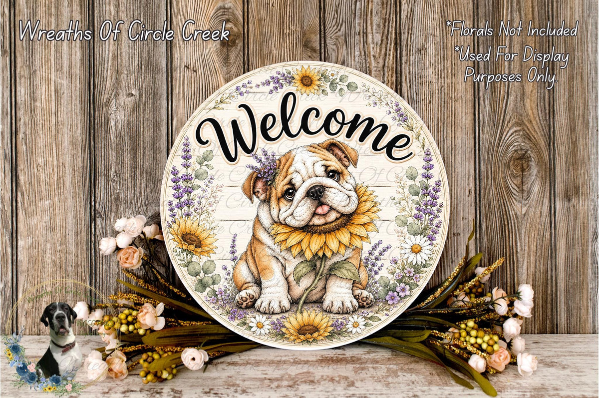 A decorative welcome sign featuring a bulldog with a sunflower in its mouth, surrounded by flowers and placed on a wooden surface.