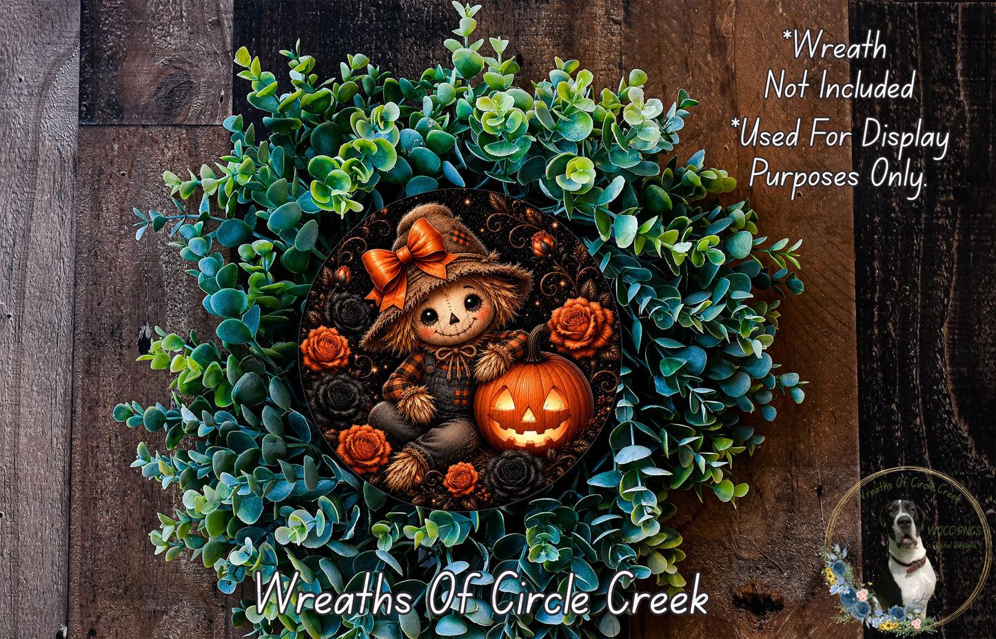 a Halloween-themed wreath with a scarecrow figure, a carved pumpkin, and various greenery. The wreath is displayed on a wooden surface, and there is a small dog in the background.