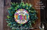 a colorful wreath made of green leaves and flowers, with the text "Little Monsters LIVE HERE" displayed prominently in the center.