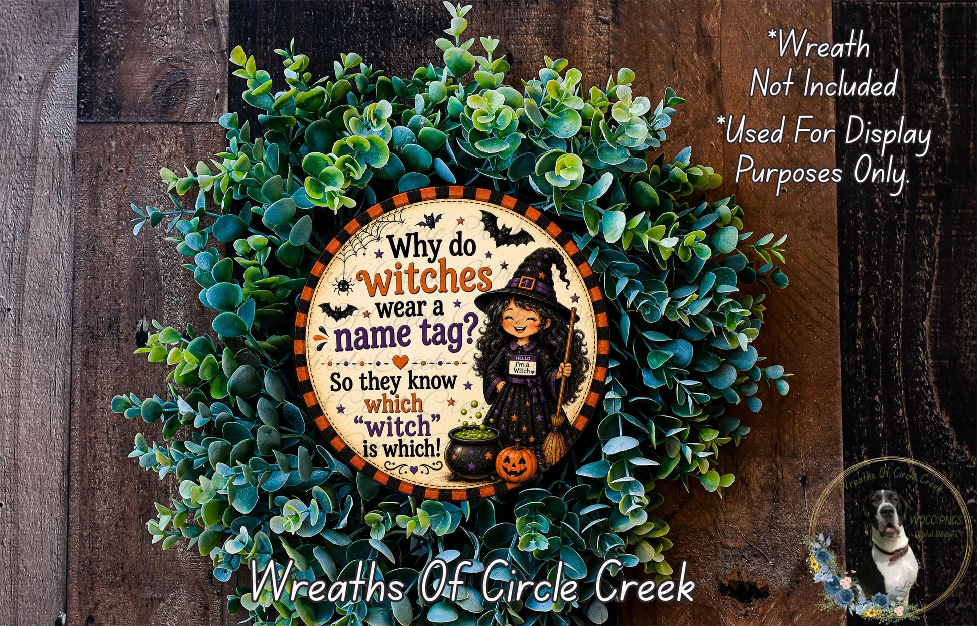 a Halloween-themed wreath with a central circular sign that reads "Why do witches wear a name tag? So they know which witch is which!" The wreath is made of green leaves and has a pumpkin and a witch figure on it. The sign is surrounded by the wreath, and there is a small dog in the bottom right corner of the image.