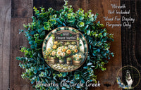 a wreath made of various green and yellow flowers, including roses and other foliage, displayed on a wooden surface. The wreath is labeled as an &quot;Irish Flower Market&quot; and is described as a &quot;Wreath of Circle Creek&quot;.