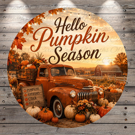 A vintage orange truck surrounded by pumpkins, hayrides, cider, and fall fun, with a sign that reads "Hello Pumpkin Season" against a backdrop of a sunset and autumn foliage.