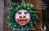 A wreath made of green leaves and red bricks, with a pair of Santa Claus shoes on top of the brick chimney.