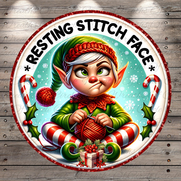 A cartoon image of a smiling elf wearing a green hat and striped pants, holding a ball of yarn and knitting. The text "RESTING STITCH FACE" is written around the image, and there are Christmas-themed elements such as candy canes and holly leaves.