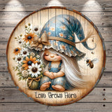A round wooden plaque with a young girl wearing a blue hat and holding a bouquet of flowers, with a bee flying nearby.
