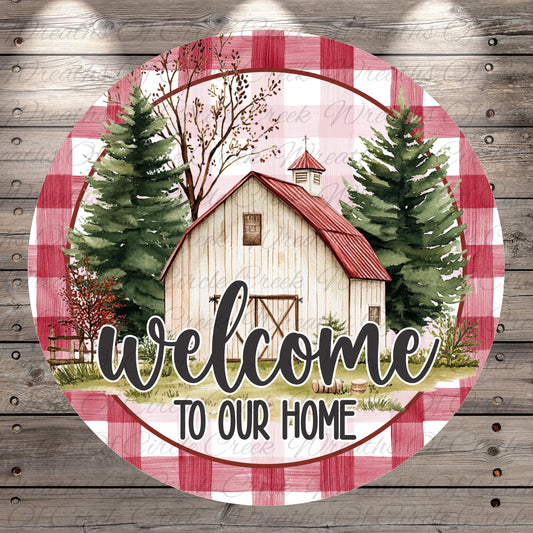 A circular sign with a rustic barn and pine trees, surrounded by a red and white checkered pattern, with the text "Welcome to Our Home" displayed prominently.
