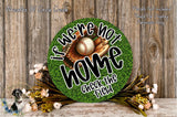 a round sign with the text "If we're not home, check the field" on it, surrounded by a baseball glove and ball, and a floral arrangement.